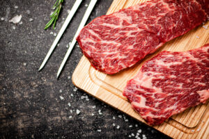 Raw steak on a wooden cutting board - The Wagyu Experience - The Wagyu Experience Beautiful marbling on Wagyu steak